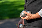 Men&#39;s hands hold petanque balls, boules pitch in the Stadtpark am Hansering, Halle an der Saale, Saxony-Anhalt, Germany