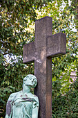 Weibliche Statue lehnt an einem Grabkreuz, Stadtgottesacker, Saalestadt Halle, Sachsen-Anhalt, Deutschland