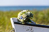 Blumenstrauß mit Rosen und Hortensien auf der Spitze eines Holzbootes