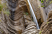 Frankreich, Alpes-de-Haute-Provence, Niedrigwinkelansicht des Wasserfalls auf erodiertem Felsen