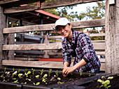 Australia, Melbourne, Smiling woman planting seedlings at community garden