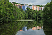 Pastel apartment buildings behind idyllic lake, Egerland, Czech Republic