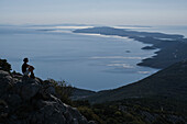 Frau genießt sonnigen Meerblick von der Klippe, Kvarner, Kroatien