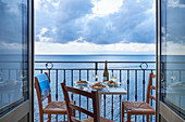 Gedeckter Tisch auf Balkon über das Meer
