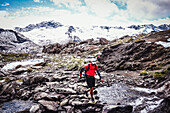 Trail runner in front of the Zillertal mountain range. The Berlin Höhenweg trail running style - multi-day tour in the Zillertal Alps