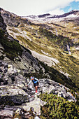 Trailrunnerin in Gebirgslandschaft am Berliner Höhenweg im Trailrunning Stil, Mehrtagestour in den Zillertaler Alpen, Tirol, Österreich