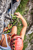 In the via ferrata - climber attaches a carabiner to a steel cable, Tyrol