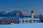 Snow-covered meadows with Wilparting Church and mountains of the Wendelstein area in the background, Irschenberg, Upper Bavaria, Bavaria, Germany