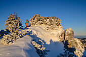 Frau beim Wandern steht auf verschneitem Bergrücken, an der Brecherspitze, Spitzinggebiet, Bayerische Alpen, Oberbayern, Bayern, Deutschland
