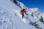 Mann auf Skitour fährt durch Pulverschneehang ab, Großer Traithen, Mangfallgebirge, Bayerische Alpen, Oberbayern, Bayern, Deutschland