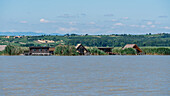 Lake houses on Lake Neusiedl with the free town of Rust in the background in Burgenland, Austria