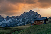Kleine Hütte vor der Geislergruppe im herbstlichen Abendlicht, Puez-Geisler, Lungiarü, Dolomiten, Italien, Europa\n