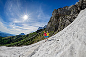 Mann und Frau beim Wandern gehen über Schneefeld, Südwandhütte, Dachstein, UNESCO Welterbe Hallstatt, Steiermark, Österreich