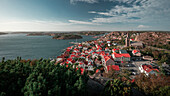 Küste und Dorf Fjällbacka vom Berg Vetteberget von oben bei Tag mit Sonne und blauem Himmel an der Westküste in Schweden\n