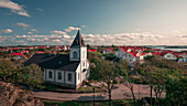 Dorfkirche von Mollösund auf der Schäreninsel Orust an der Westküste von Schweden, Sonne am Tag mit blauem Himmel\n