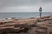 Woman on the rocky coast of Rotsidan in the east of Sweden