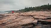 Man on the rocky coast of Rotsidan in the east of Sweden