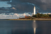Leuchtturm Lange Erik mit Reflexion im Wasser im Norden der Insel Öland im Osten von Schweden im Sonnenuntergang\n