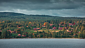 Red Swedish houses on the lakeshore of Lake Siljan in Dalarna, Sweden