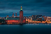 Beleuchtete Skyline von Stockholm bei Nacht mit Stadshus in Schweden\n