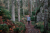 Woman hiking on hiking trail in the forest of Tiveden National Park in Sweden