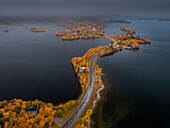 Strasse durch Saxnäs entlang der Wilderness Road mit Inseln im Herbst in Lappland in Schweden von oben\n
