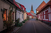 Street with Sankt Marien church in Ystad in Sweden in sunset