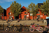 People with old warehouses at the city harbor enjoy the sun, Oulo, Finland
