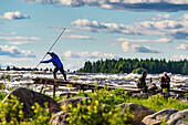Traditional local fishing with long nets. Kukkolankoski rapids on the Torne Elv river, Tornio, Finland