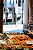 Blick auf die Auslage am Fischmarkt in Venedig, im Hintergrund ein Gondoliere, Venedig, Venetien, Italien, Europa