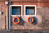 Blick auf Rettungsringe und Fischernetze am Fenster in Venedig, Venetien, Italien, Europa