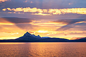 Morgenliche Sonneneinstrahlung einer Bergkette nördlich von Harstad, Hurtigrute, Nordland, Norwegen, Europa