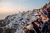 Crowds of tourists and photographers at sunset with a view over Oia, windmill, Santorini, Santorin, Cyclades, Aegean Sea, Mediterranean Sea, Greece, Europe