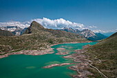 Landscape at the Lago Bianco reservoir at the Bernina Pass in the sun from above