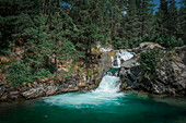 Wasserfall mit Pool am Wanderweg Cascada da Bernina beim Morteratsch Gletscher im Engadin in den Schweizer Alpen\n