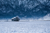 Blick auf eine Hütte im Schnee, im Hintergrund die Alpen, Voralpenland, Bayern, Deutschland, Europa
