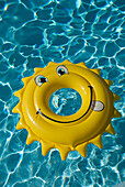 An buoy shaped line a sun, floats in a swimming pool, south of france