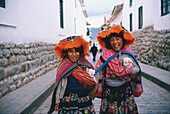 Zwei Mädchen stehen auf der Straße und halten zwei Welpen, Cuzco, Region Cusco, Peru