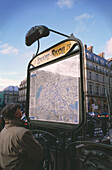 Tourist looking at metro map outside of the metro station, Louvre-Rivoli, Paris, Ile-de-France, France