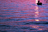 Silhouette einer Person im Boot bei Sonnenuntergang, Anzio, Italien