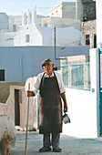 Älterer Mann mit einem Stock, der in einer Straße steht, Santorini, Kykladen, Griechenland