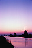 Silhouette of traditional windmills at sunset, Netherlands