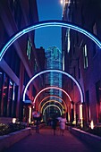 Neon beleuchteter Torbogen in einer Gasse im historischen Viertel West End mit Bank of America Building im Hintergrund, Dallas, Texas, USA