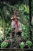 Statue eines Kriegers, der einen karierten Rock trägt und einen Löwen im Wald erobert, Bali, Indonesien