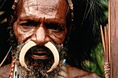 Porträt eines indigenen Mannes mit einem gebogenen Knochen in seinem Nasenpiercing, Irian Jaya, Neuguinea, Indonesien
