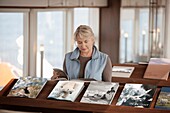 Woman looking at book in library on cruise ship sailing the British Isles