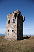 Touristen in der Nähe der Ruinen eines Gebäudes auf einem Hügel mit Blick auf den Atlantischen Ozean, Killybegs, County Donegal, Irland