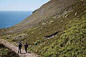 Rückansicht der Wanderer auf einem Pfad in Richtung Atlantik, Killybegs, County Donegal, Irland