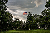 American Flag flying in a storm above a park in Baltimore.