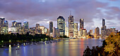 Panorama von Brisbane City am frühen Abend beleuchtet und Blick auf festgemachte Boote im Brisbane River vom Kangaroo Point